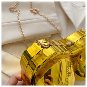 Detail of gold mirror acrylic bra bag showing shiny surface and metal chain strap