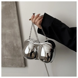 Macro shot of silver acrylic bra-shaped evening bag with metallic chain strap detail
