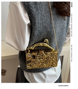 Details der goldenen Acryl-Clutch mit Eisriss-Textur und goldenem Leoparden-Griff