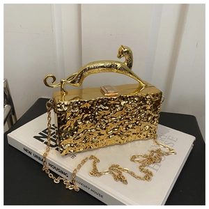 Nahaufnahme der goldenen Abendtasche mit geprägter Textur und Panther-Griff-Design