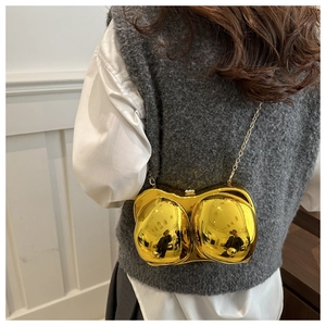 Detailed view of golden mirror anatomical bra clutch bag with chic metal chain strap