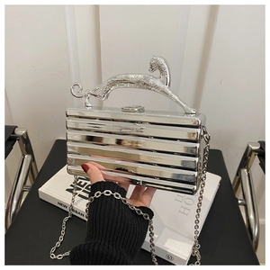 Nahaufnahme einer silbernen Acryl-Clutch mit Leoparden-Griff und eleganter Metallkette
