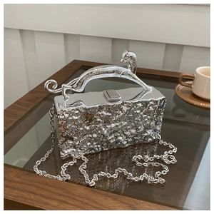 Nahaufnahme einer silbernen Clutch mit Hammerschlag-Textur und Panther-Skulpturgriff