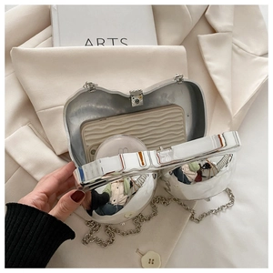 Detailed interior of a silver heart-shaped evening bag with chain and high-gloss finish