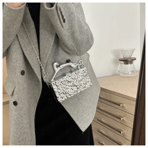 Detail der silbernen Abendtasche mit Eisriss-Textur und Geparden-Griff am Mantel