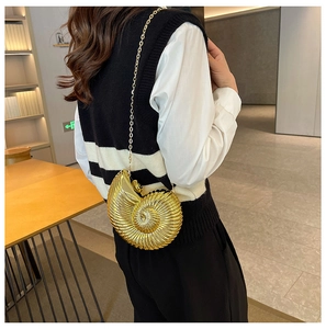 Detailed back view of a golden seashell-shaped crossbody bag with a fine metal chain strap