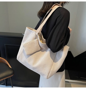Detail of a large woven tote bag with matching coin purse and wide nylon shoulder strap