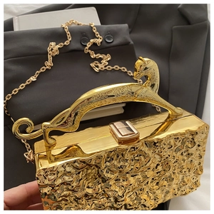Details der goldenen Abendtasche mit Eisriss-Textur und Metallgriff in Leopardenform