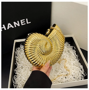 Detail of golden nautilus seashell evening clutch bag with metallic spiral texture