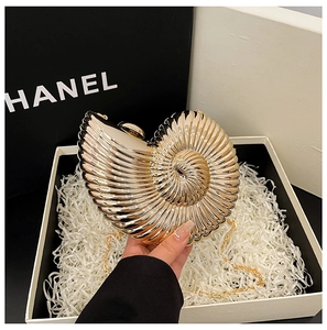 Detailed view of luxury gold conch-shaped acrylic evening bag with metal chain strap