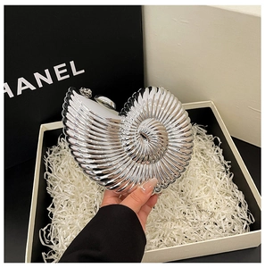 Detailed close-up of a silver nautilus-shaped acrylic clutch bag with metallic gloss finish