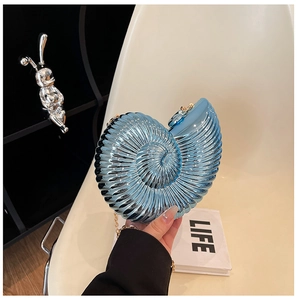 Macro shot of light blue nautilus shell evening bag with golden chain strap and spiral texture