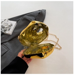 Detail of gold acrylic evening clutch with irregular geometric surface and chain