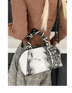 Detalle del elegante bolso de mano y bandolera con patrón de cocodrilo y serpiente.