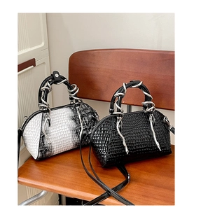 Bolso de mano para mujer con estampado de serpiente y asa metalica de serpiente chic.