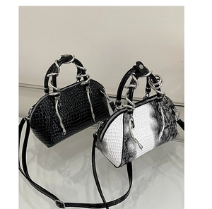 Vista detallada de bolsos de mujer modernos con asas de serpiente plateadas y textura de cocodrilo.