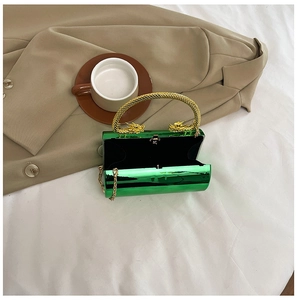 Détail de la pochette en acrylique vert métallisé avec anses dragon dorées et chaîne