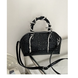 Bolso de mano negro con textura de cocodrilo y detalle de asa de serpiente plateada.