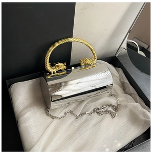 Détail d'un sac de soirée argenté avec poignée double dragon dorée en boîte cadeau