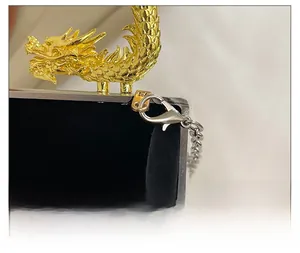 Détail macro du fermoir dragon doré et de la chaîne sur le sac de soirée en acrylique