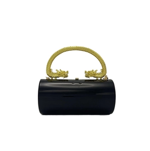 Détail du sac de soirée cylindrique noir avec des poignées dorées en forme de dragon