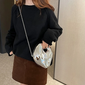 Irregular silver liquid-metal crossbody bag with chain strap on fashion model