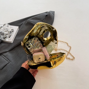 Gold mirror acrylic evening clutch bag with chain strap showing internal storage capacity