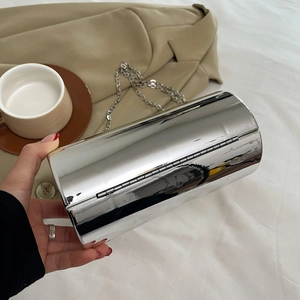 Détail de la pochette cylindrique argentée avec fini miroir brillant et bandoulière chaîne