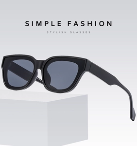 Close-up of classic black oversized square sunglasses on a white geometric display