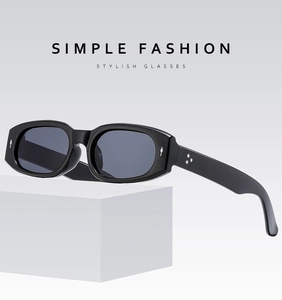 Detail einer schwarzen rechteckigen Sonnenbrille mit silbernen Stern- und Rauten-Beschlägen