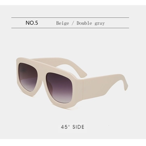 Dettaglio occhiali da sole oversize beige con lenti sfumate e aste laterali spesse