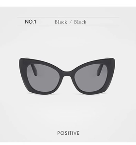 Front view of elegant black cat-eye sunglasses with dark lenses in high-gloss finish