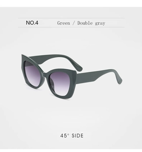 Detail view of cat eye sunglasses in green frame with purple gradient lenses
