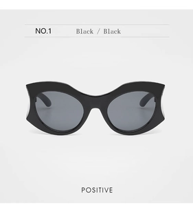 Front view of bold black geometric cat-eye sunglasses with thick frames and dark lenses
