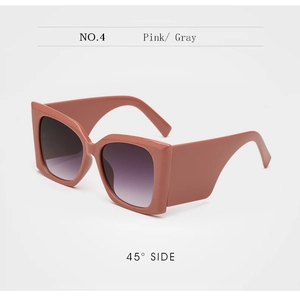 Detail view of pink oversized square sunglasses with thick temples and grey gradient lenses