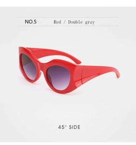 Detail view of bold red cat-eye sunglasses with gradient lenses at a 45-degree angle