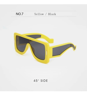 Vue latérale de lunettes de soleil carrées jaunes avec branches ondulées et verres foncés