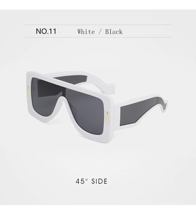 Gros plan sur des lunettes de soleil blanches oversize avec branches ondulées et détail doré