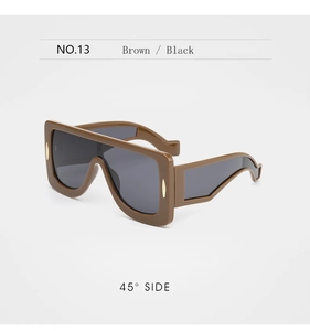 Détail de lunettes cyber oversize marron avec ornements en métal doré sur les branches