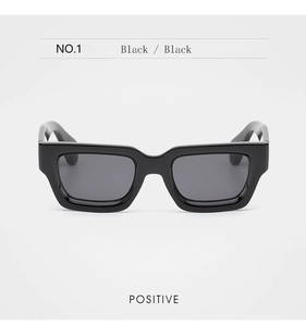 Vue de face des lunettes de soleil carrées noires élégantes avec une monture épaisse