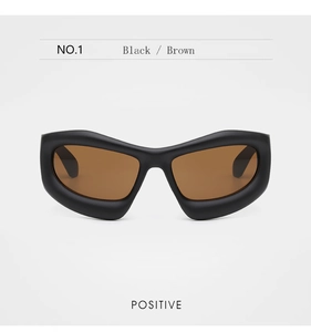 Front view of thick black matte sunglasses with brown lenses and futuristic frame