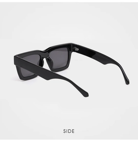 Side view of trendy rectangular oversized sunglasses with thick black frames and dark lenses
