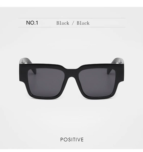 Front view of retro black thick-frame sunglasses with high-gloss finish and dark grey lenses