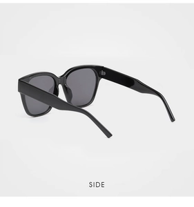 Vue latérale de lunettes de soleil noires surdimensionnées à monture épaisse et verres gris