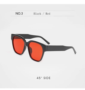 Détail de lunettes de soleil noires surdimensionnées avec verres rouges et branches larges