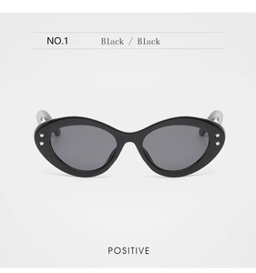 Macro detail of cat-eye sunglasses with black glossy frames and silver star rivets
