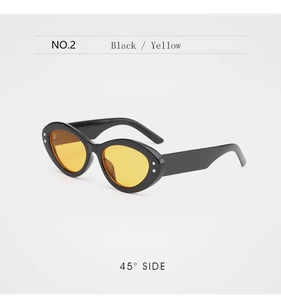 Detail of retro cat-eye sunglasses with silver star studs and yellow tinted lenses