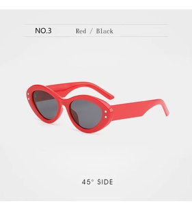 Detail shot of red cat-eye sunglasses featuring silver star-shaped rivets and dark lenses