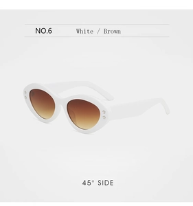 Detail view of white oval sunglasses with silver star studs and brown gradient lenses