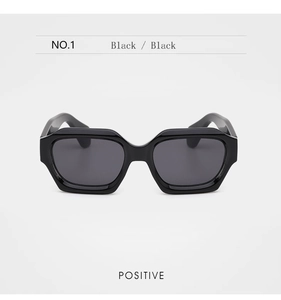 Vue frontale de lunettes de soleil noires à monture géométrique épaisse et verres foncés